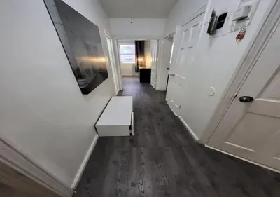 a hallway with a white door and a bench at Four Bedroom Prime Furnished Rental, June To Aug 90 Days Stay Required in New York