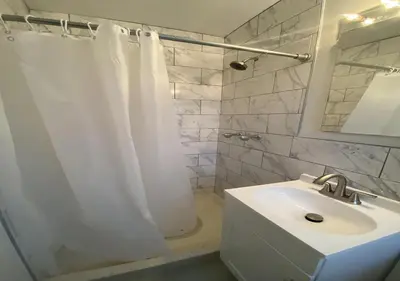 a bathroom with a white shower curtain and a sink at Great Location! Spacious 3BR Loft in Midtown West!, June To Aug 90 Days Stay Required in New York