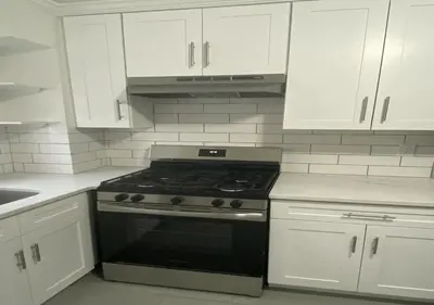 a kitchen with a stove and white cabinets at Great Location! Spacious 3BR Loft in Midtown West!, June To Aug 90 Days Stay Required in New York