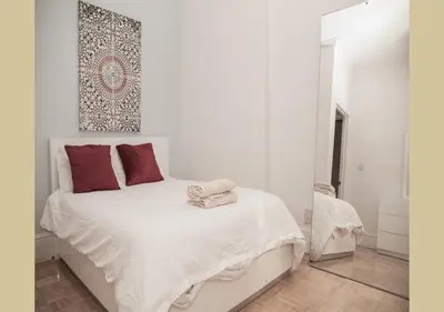 a white bedroom with a white bed with red pillows at Great Location! Spacious 3BR Loft in Midtown West!, June To Aug 90 Days Stay Required in New York