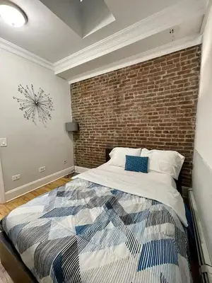 a bedroom with a brick wall and a bed at Great Location! Spacious 3BR Loft in Midtown West!, June To Aug 90 Days Stay Required in New York