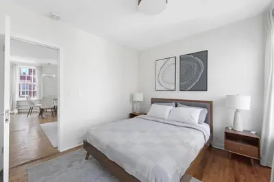 a white bedroom with a bed and a dining room at Best Location in Greenwich Village in New York