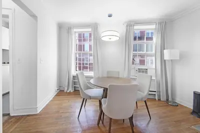 a dining room with a wooden table and white chairs at Best Location in Greenwich Village in New York