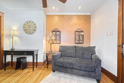 a living room with a couch and a piano at Suites On Chocolate - The Hershey House in Hershey