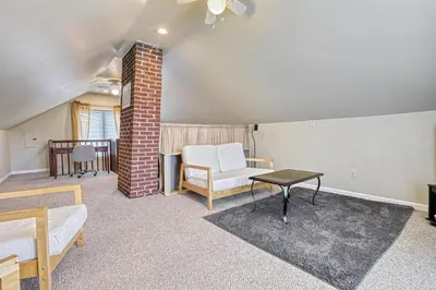a room with a bed and a chair and a table at Suites On Chocolate - The Hershey House in Hershey