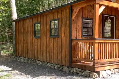 a log cabin with a porch and windows at Close to Trails Studio with Water Views in Wurtsboro