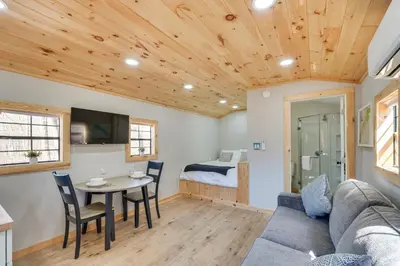a living room with a couch and a table and a bed at Close to Trails Studio with Water Views in Wurtsboro