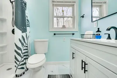 a blue bathroom with a toilet and a sink at Hike and Fish Outdoor Retreat Near Trails in Wurtsboro