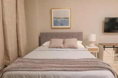 a bedroom with a bed and a table with a television at Private Studio 5 minutes to the NYC train in Bayonne