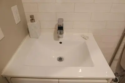 a white sink in a bathroom with aaucet at Private Studio 5 minutes to the NYC train in Bayonne