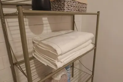 a bunch of towels on a shelf in a room at Private Studio 5 minutes to the NYC train in Bayonne