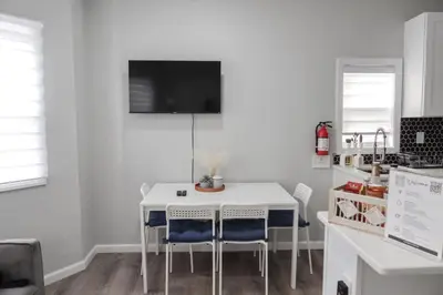 a white kitchen with a white table and chairs at 3Bed 2Bath Apt Near NYC plus Parking and Laundry in Irvington