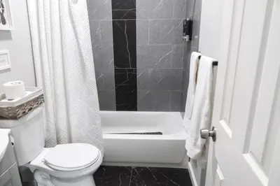 a bathroom with a toilet and a tub and a shower at 3Bed 2Bath Apt Near NYC plus Parking and Laundry in Irvington