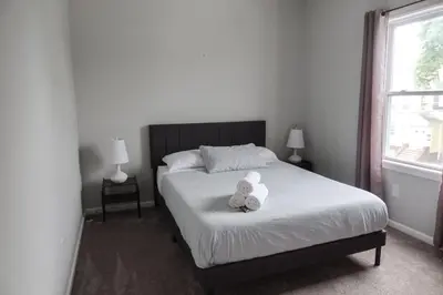 a teddy bear sitting on a bed in a bedroom at 5Bed 2Bath Near NYC, Parking, Laundry in Irvington
