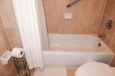 a bathroom with a white tub and a toilet at 1Bed 1Bath Apt near EWR, Parking 18 min from Penn St. in Newark