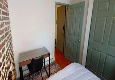 a room with a bed and a door and a chair at Charming 3BR Apartment in NYC in New York