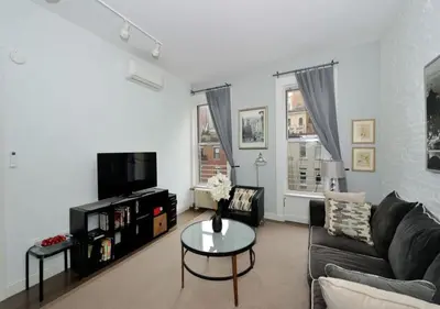 a living room with a couch and a table at 1BR GEM! Close to Central Park!, June To Aug 90 Days Stay Required in New York