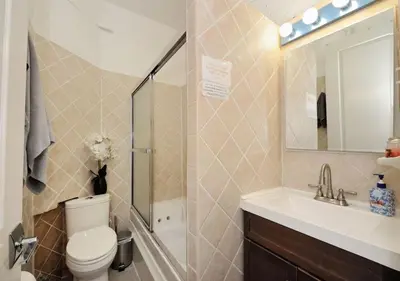 a bathroom with a toilet and a sink and a mirror at 1BR GEM! Close to Central Park!, June To Aug 90 Days Stay Required in New York