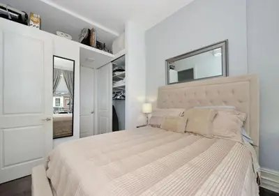 a white bedroom with a large bed and a mirror at 1BR GEM! Close to Central Park!, June To Aug 90 Days Stay Required in New York