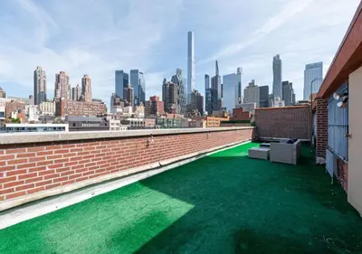 a green floor on a roof with a view of a city at Amazing Furnished 1 BR Midtown West in New York