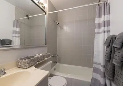 a bathroom with a tub and a sink and a toilet at Amazing Furnished 1 BR Midtown West in New York