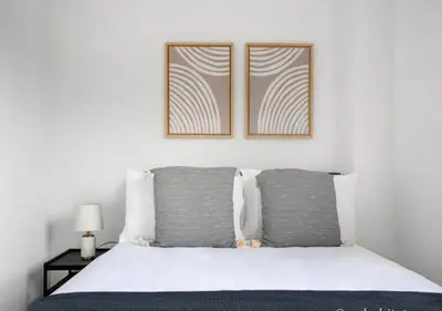 a bedroom with a bed with two pictures on the wall at 3BR Furnished Loft in Midtown West in New York