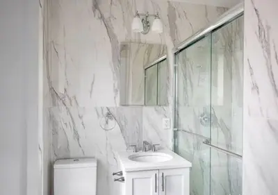 a marble bathroom with a sink and a shower at 3BR Furnished Loft in Midtown West in New York