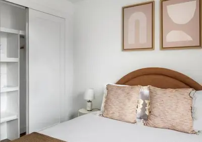 a bedroom with a white bed with a wooden headboard at 3BR Furnished Loft in Midtown West in New York
