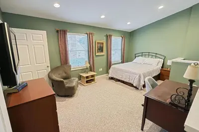 a bedroom with a bed and a desk and a tv at Suites On Chocolate - The School in Hershey