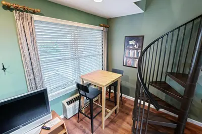 a small room with a table and a staircase at Suites On Chocolate - The School in Hershey