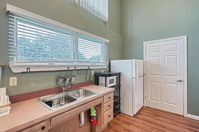 a kitchen with a sink and a refrigerator at Suites On Chocolate - The School in Hershey
