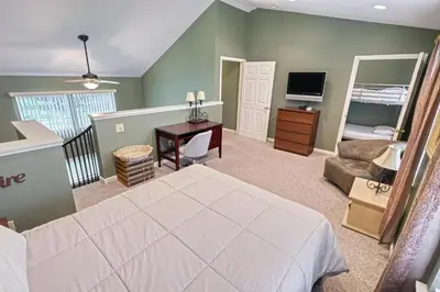 a bedroom with a bed and a desk and a television at Suites On Chocolate - The School in Hershey