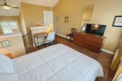 a bedroom with a bed and a desk and a television at Suites On Chocolate - The Theater in Hershey