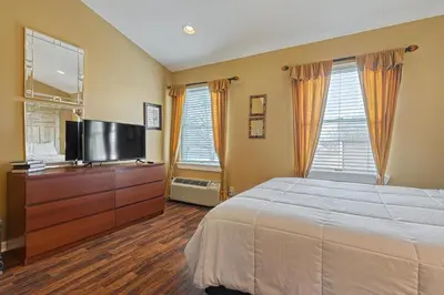 a bedroom with a bed and a flat screen tv at Suites On Chocolate - The Theater in Hershey