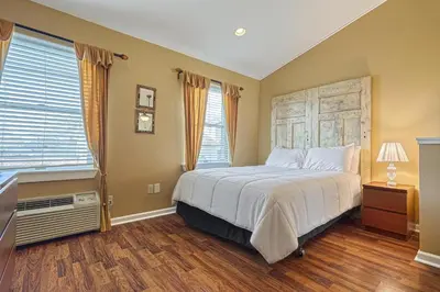 a bedroom with a large bed and two windows at Suites On Chocolate - The Theater in Hershey