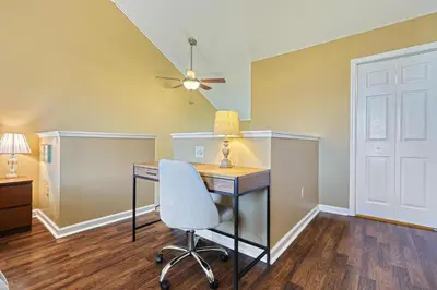 a room with a desk with a chair and a ceiling fan at Suites On Chocolate - The Theater in Hershey