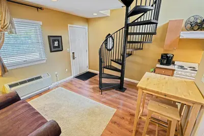 a living room with a spiral staircase in a house at Suites On Chocolate - The Theater in Hershey