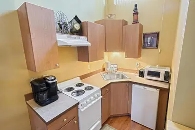 a small kitchen with a stove and a microwave at Suites On Chocolate - The Theater in Hershey