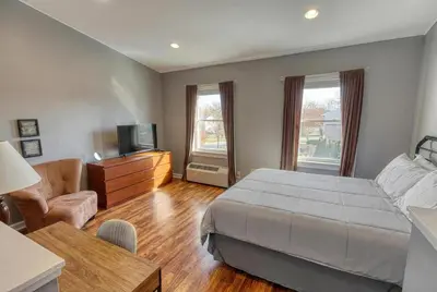 a bedroom with a bed and a living room at Suites On Chocolate - The Factory in Hershey
