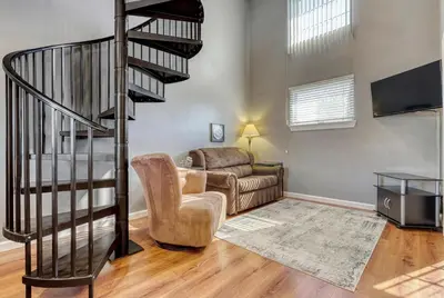 a living room with a staircase and a couch at Suites On Chocolate - The Factory in Hershey