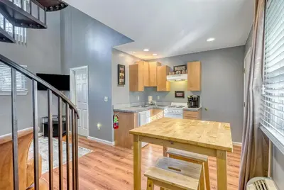 a kitchen with a wooden table and a staircase at Suites On Chocolate - The Factory in Hershey