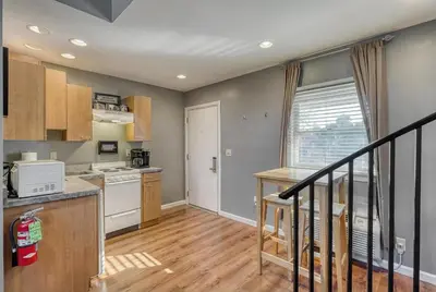 a kitchen with wooden floors and a staircase at Suites On Chocolate - The Factory in Hershey