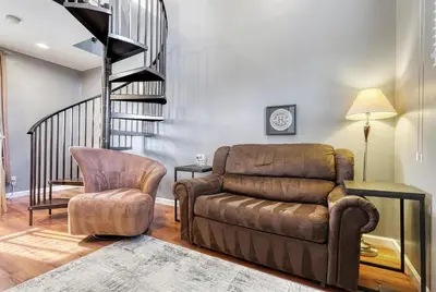 a living room with a couch and a chair at Suites On Chocolate - The Factory in Hershey