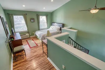 a bedroom with a bed and a staircase in a room at Suites On Chocolate - The Club in Hershey