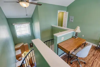 a room with a desk and a staircase with green walls at Suites On Chocolate - The Club in Hershey