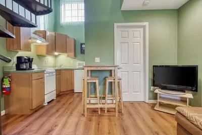 a kitchen with a table and a tv in a room at Suites On Chocolate - The Club in Hershey