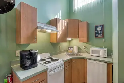 a kitchen with a white stove top oven next to a microwave at Suites On Chocolate - The Club in Hershey