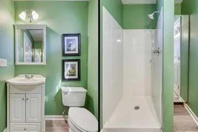 a green bathroom with a toilet and a shower at Suites On Chocolate - The Club in Hershey