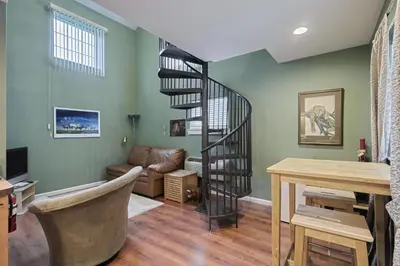 a spiral staircase in a living room with a desk at Suites On Chocolate - The Zoo in Hershey