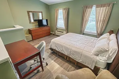 a bedroom with a bed and a desk and a tv at Suites On Chocolate - The Zoo in Hershey